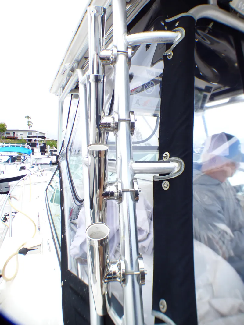 Slide: The Image of 2004 Robalo R265 Walkaround boat with stainless steel rod holders and protective canopy. - 26