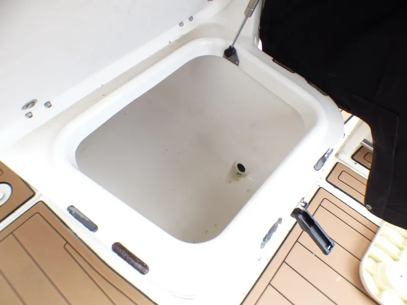 Slide: The Image of 2004 Robalo R265 Walkaround boat storage compartment with open lid. - 27