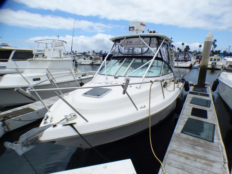 Slide: The Image of 2004 Robalo R265 Walkaround boat docked at marina under cloudy sky. - 4