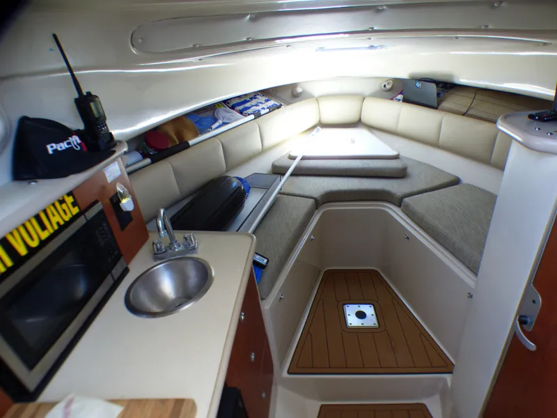 Slide: The Image of 2004 Robalo R265 Walkaround cabin interior with kitchenette, seating, and storage. - 5