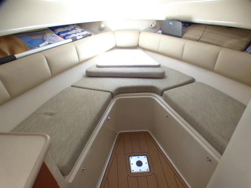 Slide: The Image of 2004 Robalo R265 Walkaround cabin interior with beige seating and wooden flooring. - 6