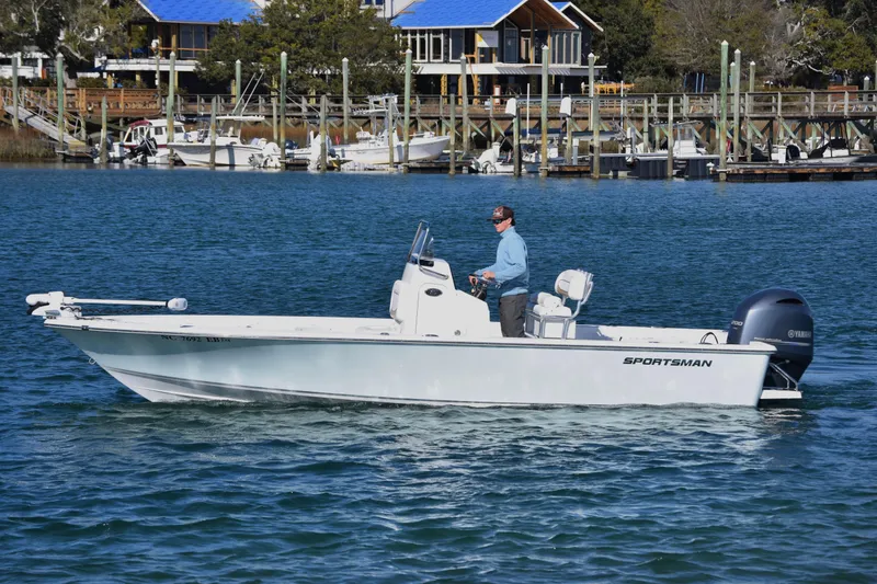 The Image of 2015 Sportsman Masters 227 Bay Boat cruising on a scenic waterfront. - 1