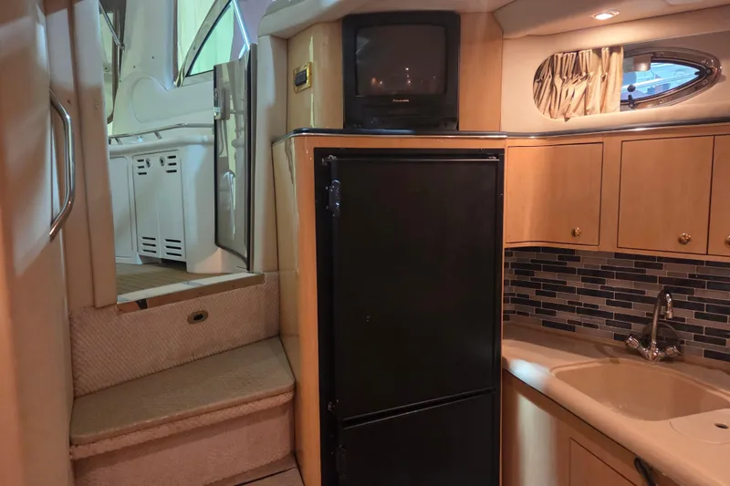 Slide: The Image of Interior of 2000 Sea Ray 410 Sundancer yacht with kitchenette, fridge, and stairs. - 24