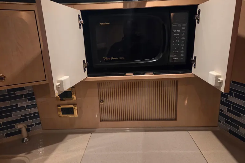 Slide: The Image of Microwave in 2000 Sea Ray 410 Sundancer yacht kitchen with open cabinet doors. - 28