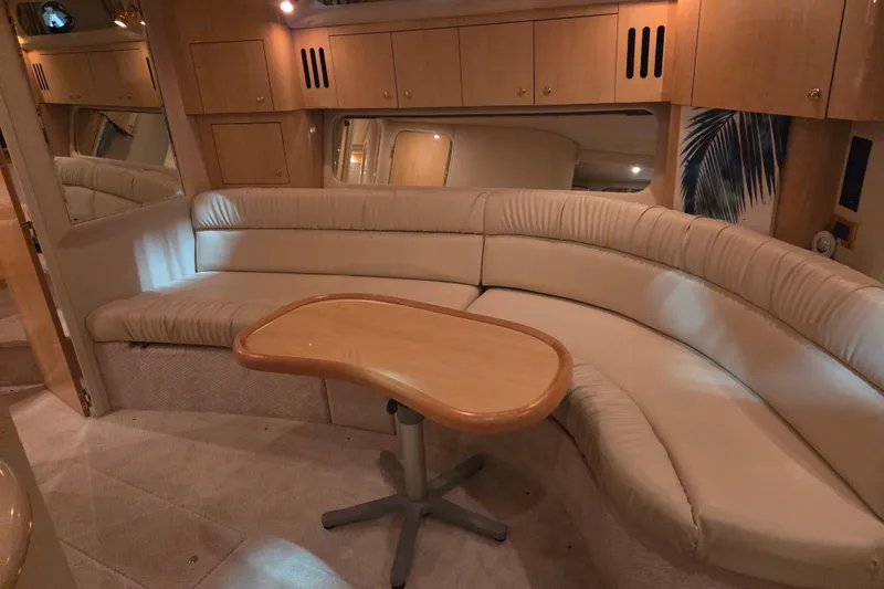 Slide: The Image of Interior of 2000 Sea Ray 410 Sundancer yacht with curved seating and wooden table. - 31