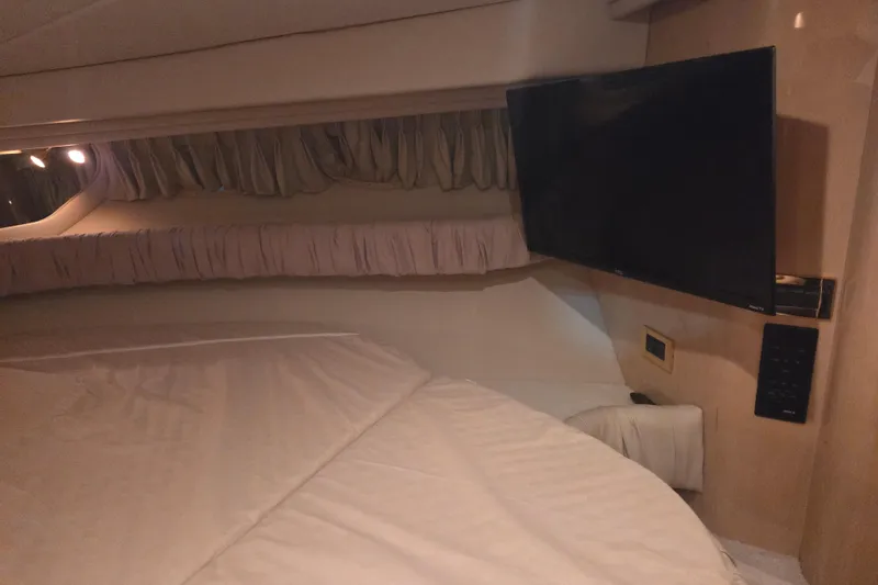 Slide: The Image of Interior cabin of 2000 Sea Ray 410 Sundancer with bed and mounted TV. - 36