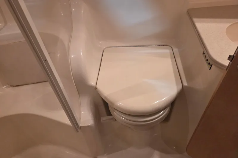 Slide: The Image of Bathroom interior of 2000 Sea Ray 410 Sundancer yacht, featuring a compact toilet. - 39