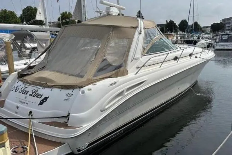 Slide: The Image of 2000 Sea Ray 410 Sundancer yacht docked in marina, featuring sleek design and beige canopy. - 4
