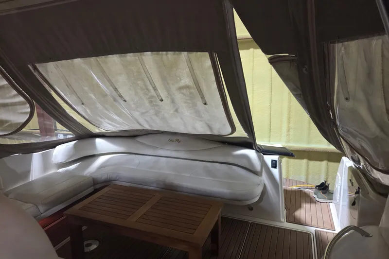 Slide: The Image of Interior of a 2000 Sea Ray 410 Sundancer with white seating and wooden table. - 50