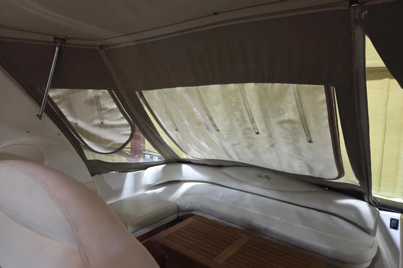 Slide: The Image of Interior of 2000 Sea Ray 410 Sundancer with cushioned seating and wooden table. - 53