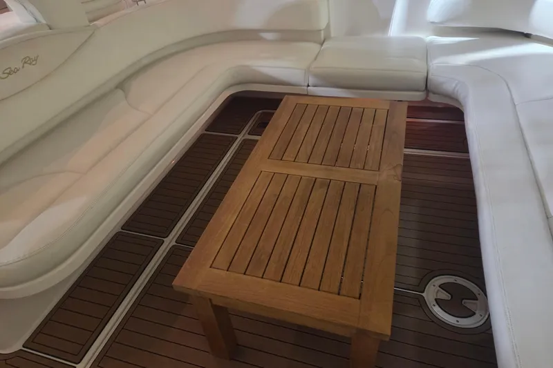 Slide: The Image of Interior of 2000 Sea Ray 410 Sundancer with white seating and wooden table. - 57