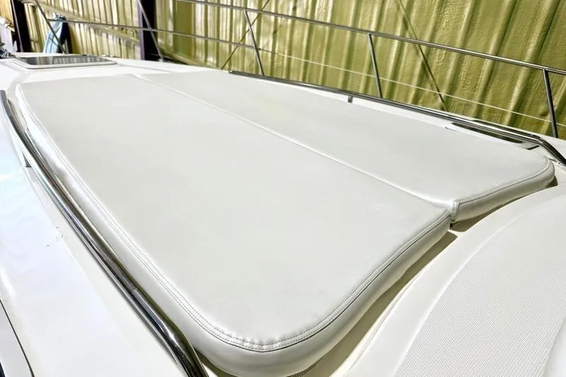 Slide: The Image of Sunpad on 2000 Sea Ray 410 Sundancer yacht, featuring sleek white cushions and stainless steel railings. - 65