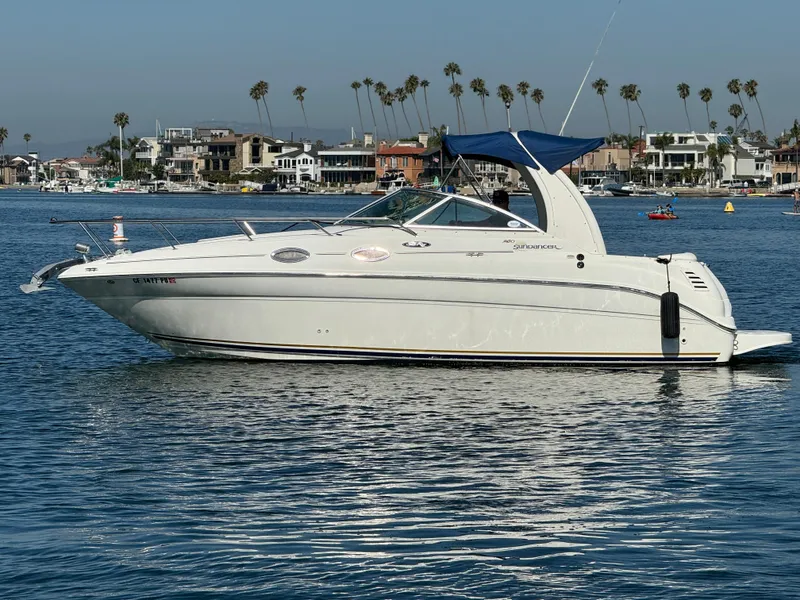 The Image of 2003 Sea Ray 260 Sundancer boat on calm water with coastal homes in the background. - 0