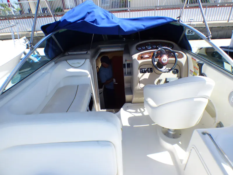 Slide: The Image of 2003 Sea Ray 260 Sundancer boat interior with helm, seating, and cabin entrance. - 14