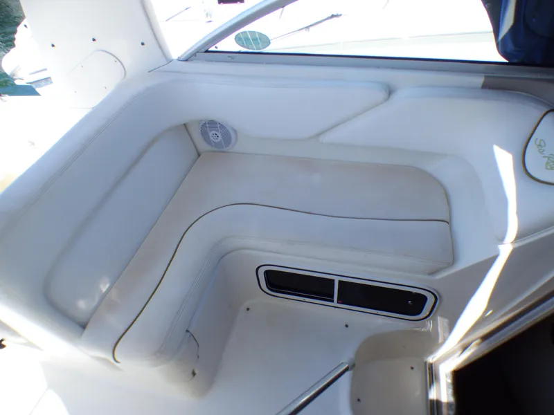 Slide: The Image of 2003 Sea Ray 260 Sundancer interior seating area with white upholstery and speaker. - 15