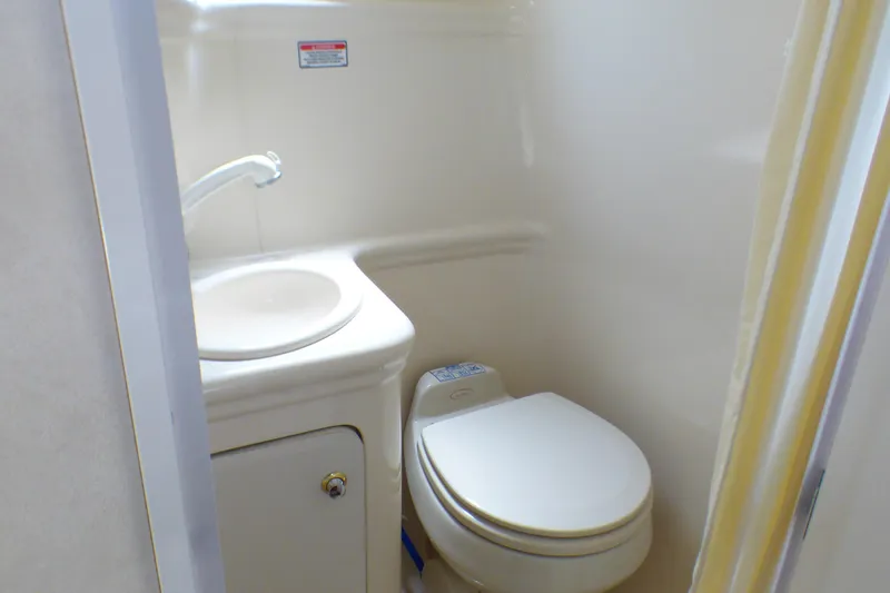 Slide: The Image of Compact bathroom in 2003 Sea Ray 260 Sundancer boat with sink and toilet. - 27