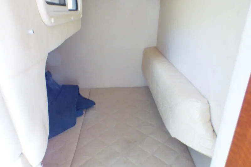 Slide: The Image of 2003 Sea Ray 260 Sundancer cabin interior with beige upholstery and compact sleeping area. - 30