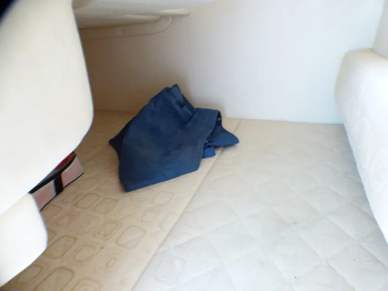 Slide: The Image of Interior cabin of 2003 Sea Ray 260 Sundancer with folded blue fabric. - 31