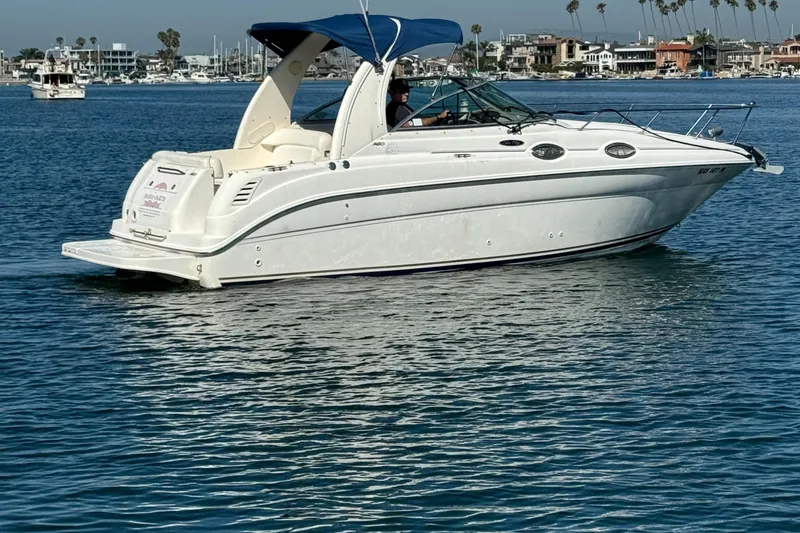 Slide: The Image of 2003 Sea Ray 260 Sundancer boat cruising on calm blue water. - 6