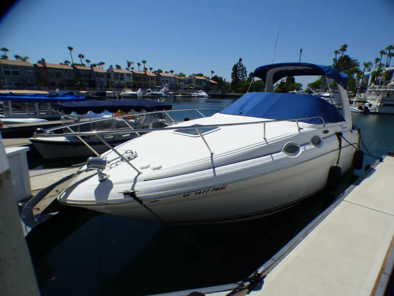 Slide: The Image of 2003 Sea Ray 260 Sundancer docked in a marina under clear blue skies. - 8