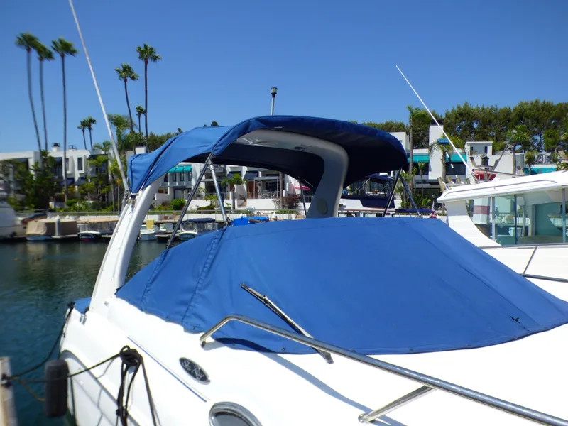 Slide: The Image of 2003 Sea Ray 260 Sundancer boat with blue cover docked in marina. - 9