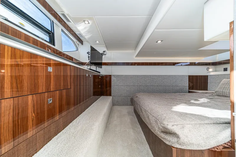 Slide: The Image of Luxurious interior of 2023 Cruisers Yachts 42 Cantius with modern wood finish and cozy bed. - 36