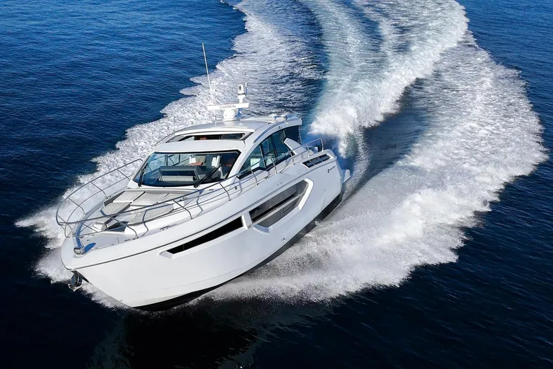 The Image of 2023 Cruisers Yachts 42 Cantius cruising on open water, creating a dynamic wake. - 0