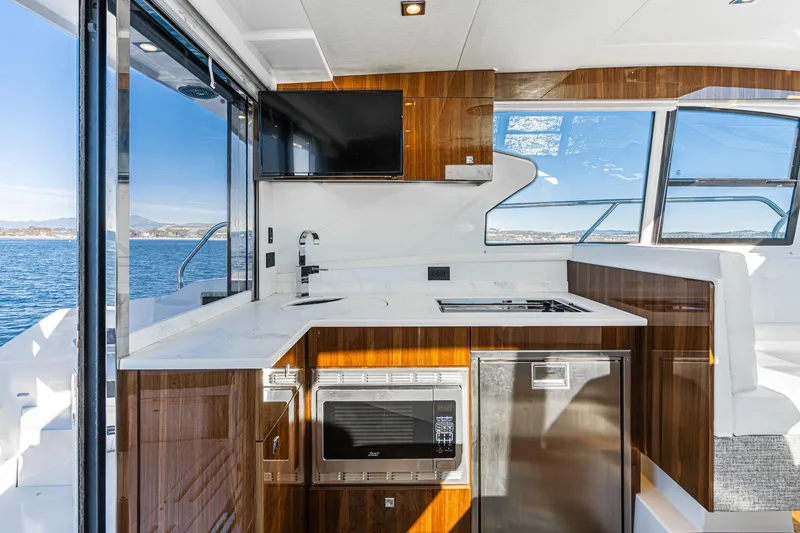 Slide: The Image of Luxurious 2023 Cruisers Yachts 42 Cantius kitchen with modern appliances and ocean view. - 17