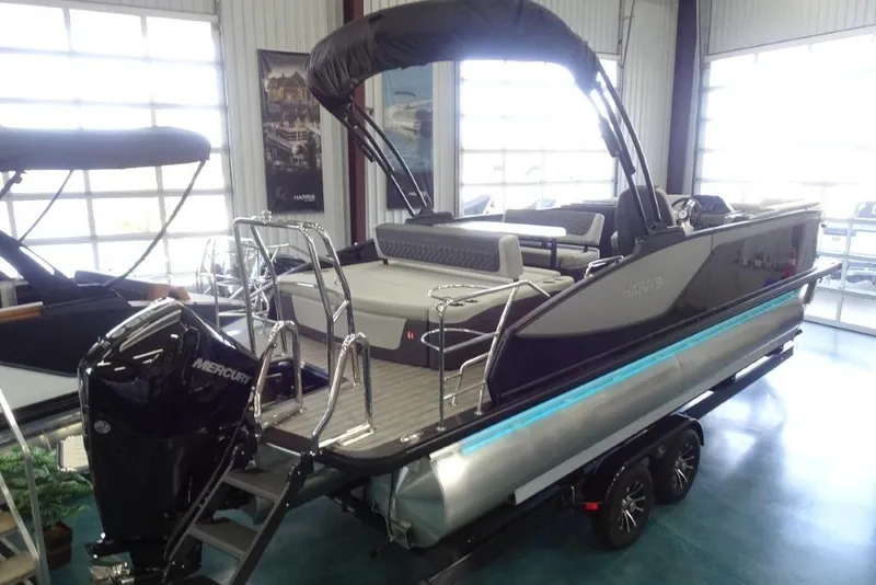 Slide: The Image of 2026 Harris Sunliner 250 pontoon boat with Mercury engine in showroom. - 4