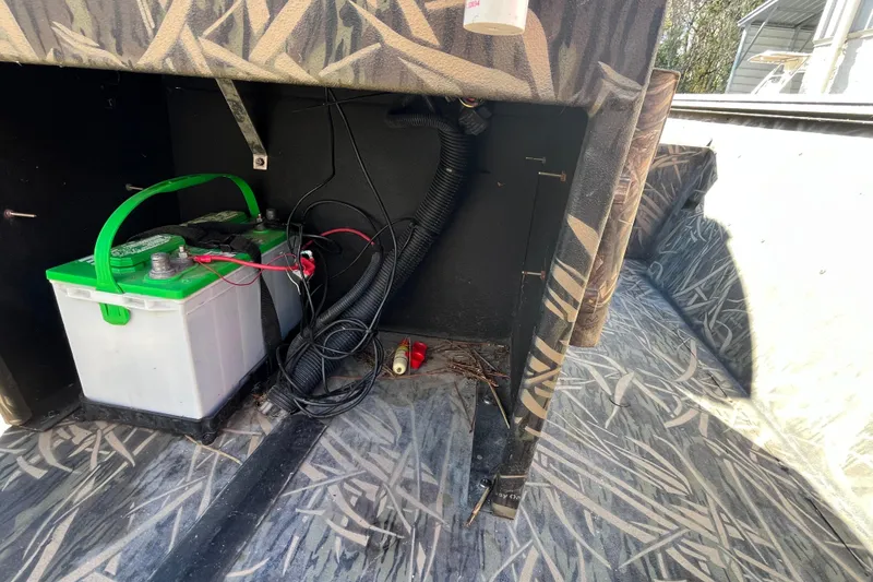 Slide: The Image of 2018 Lowe Roughneck 1760CC boat interior with battery and wiring setup. - 14