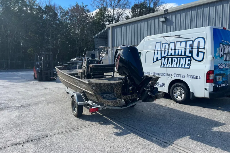 Slide: The Image of 2018 Lowe Roughneck 1760CC boat on trailer near Adamec Marine service van. - 2