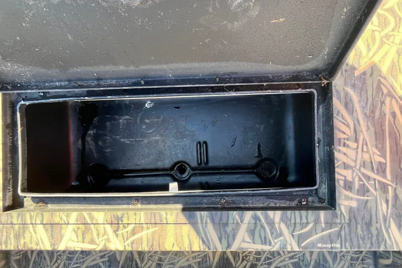 Slide: The Image of Open storage compartment on 2018 Lowe Roughneck 1760CC boat, featuring camo design. - 20