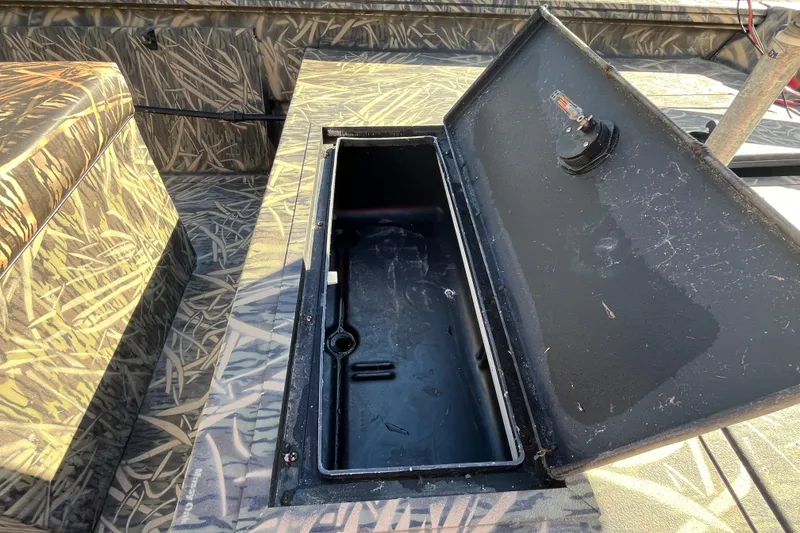 Slide: The Image of Open storage compartment on 2018 Lowe Roughneck 1760CC boat with camouflage pattern. - 25