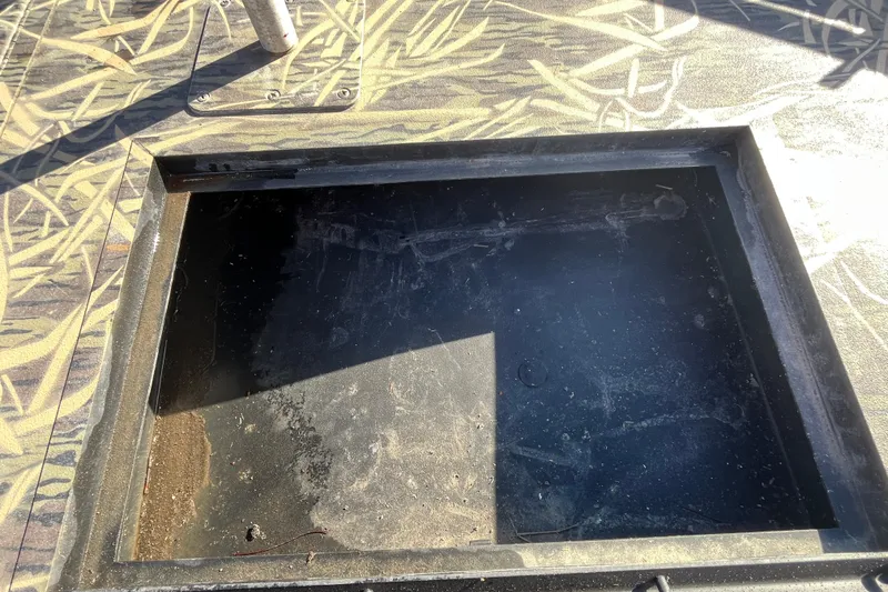 Slide: The Image of Open storage compartment on 2018 Lowe Roughneck 1760CC boat with camouflage pattern. - 26