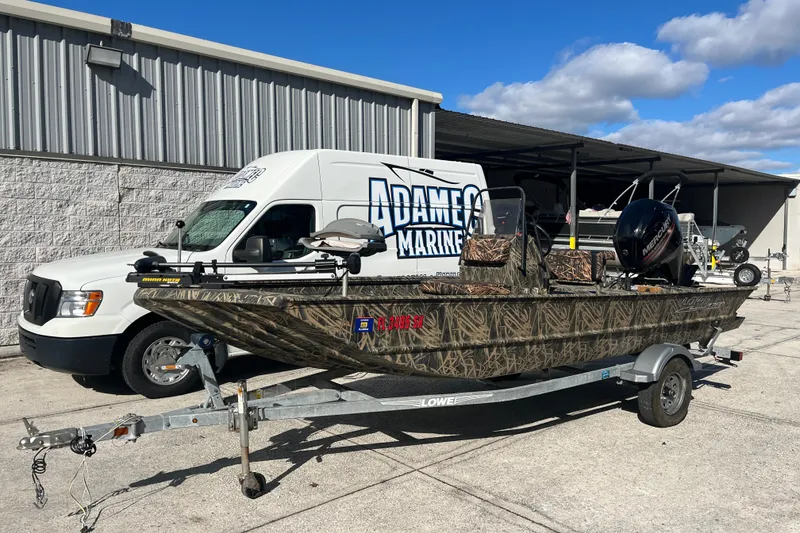 Slide: The Image of 2018 Lowe Roughneck 1760CC boat on trailer, parked near Adamec Marine van. - 5