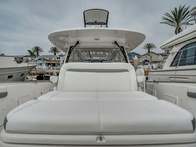 Slide: The Image of 2015 Everglades 435 Center Console boat in harbor, featuring luxurious seating area. - 21