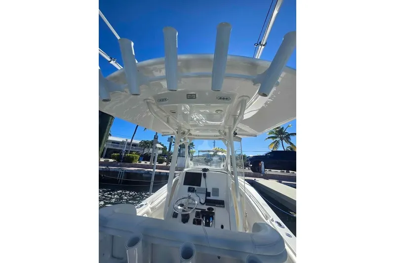 Slide: The Image of 2017 Regulator 25 boat interior with helm, rod holders, and clear blue sky. - 10