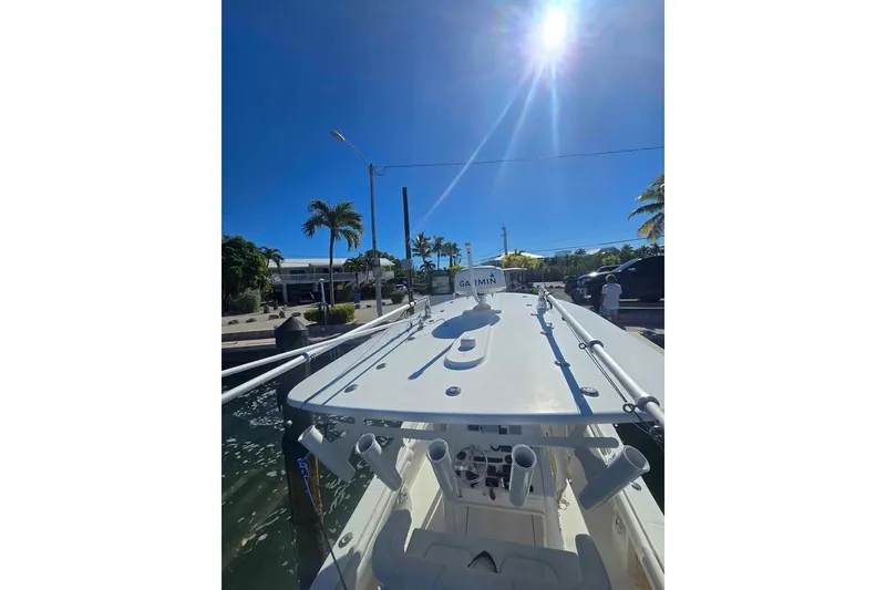 Slide: The Image of 2017 Regulator 25 boat docked under clear blue sky with palm trees. - 11