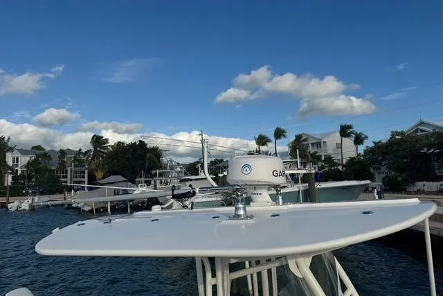 Slide: The Image of 2017 Regulator 25 boat docked at marina under clear blue sky. - 17