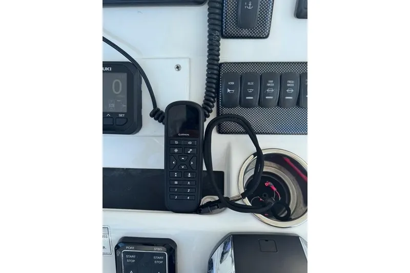 Slide: The Image of Control panel of a 2017 Regulator 25 boat with Garmin device and switches. - 18