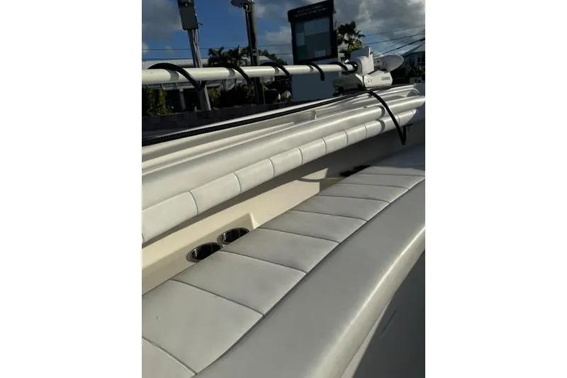 Slide: The Image of 2017 Regulator 25 boat interior with white cushioned seating and cup holders. - 21