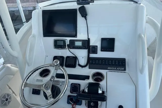 Slide: The Image of 2017 Regulator 25 boat dashboard with steering wheel, electronic controls, and navigation displays. - 30
