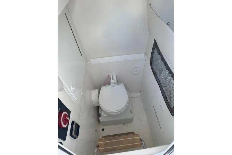 Slide: The Image of 2017 Regulator 25 boat interior with compact marine toilet and storage. - 32