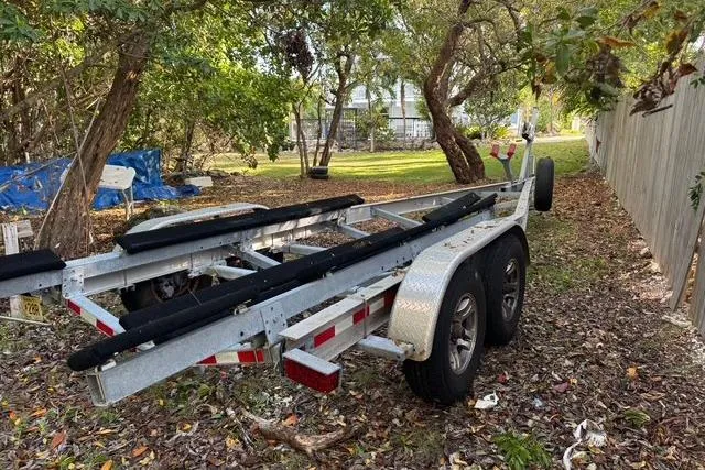 Slide: The Image of 2017 Regulator 25 boat trailer parked in a wooded area. - 39