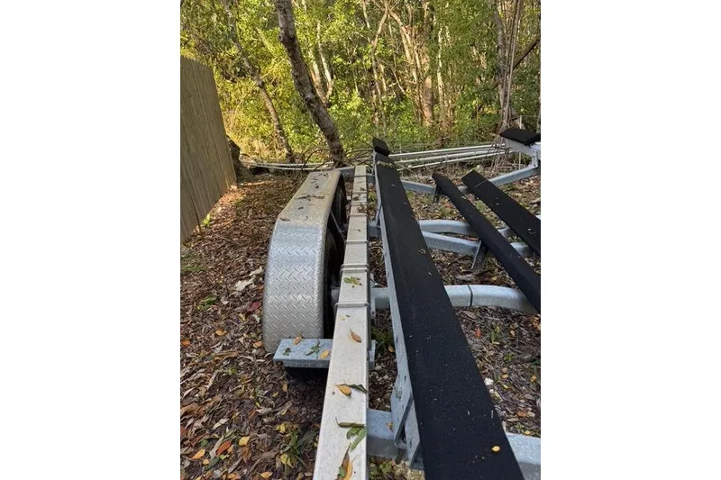 Slide: The Image of Trailer for 2017 Regulator 25 boat in wooded area, surrounded by leaves. - 40