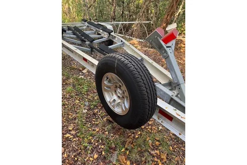 Slide: The Image of Trailer for 2017 Regulator 25 boat with spare tire in wooded area. - 42