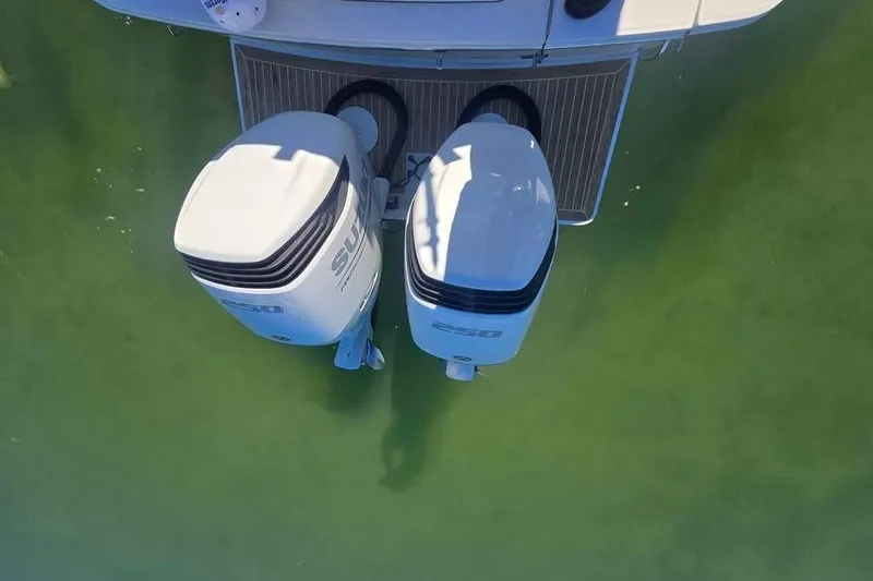 Slide: The Image of 2017 Regulator 25 boat with dual outboard engines on calm water. - 7