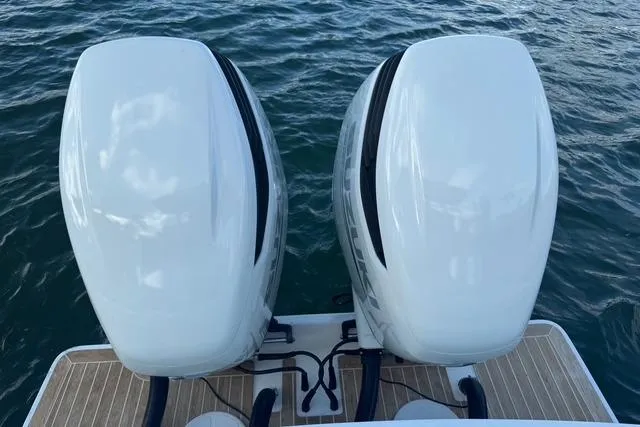 Slide: The Image of Twin outboard motors on a 2017 Regulator 25 boat, floating on water. - 8