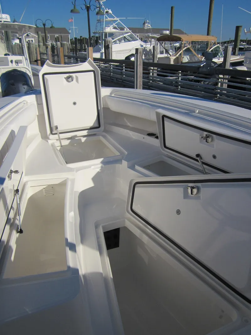 Slide: The Image of 2014 Regulator 25 boat with open storage compartments in harbor. - 13