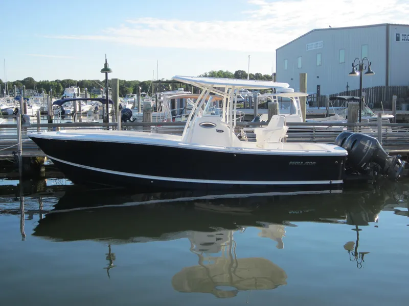 Slide: The Image of 2014 Regulator 25 boat docked at marina, side view. - 2